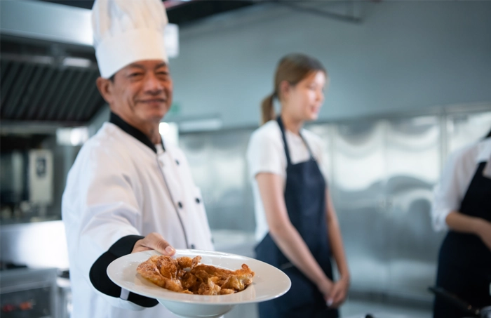 chef holding a plate of food