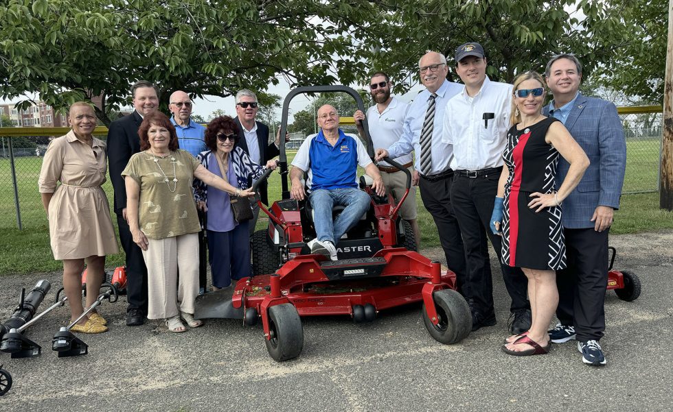 East Meadow Little League Inaugural Mow participants with ride-on mower.